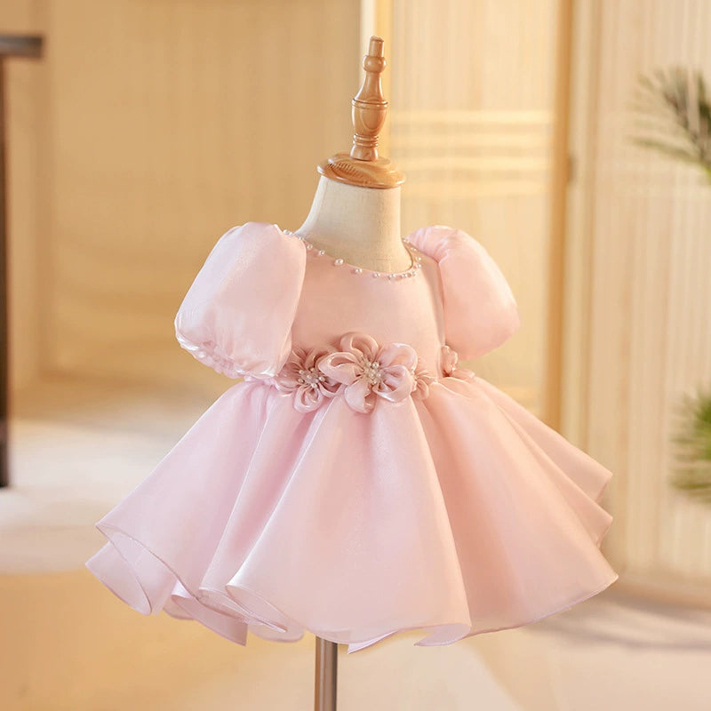 ✨ Descrizione del Vestito Rosa:

Un abito da principessa elegante e delicato in un rosa cipria incantevole, realizzato in organza, una tela trasparente e luminosa che conferisce un tocco di magia e raffinatezza al look. Questa stoffa è perfetta per creare volume grazie ai suoi plissettati verticali, che fanno sì che l'abito fluttui in modo etereo. La parte inferiore del vestito è arricchita da due fiocchi in organza a forma di rosa con perle, che aggiungono un dettaglio sofisticato e prezioso.

🌸 Caratteri