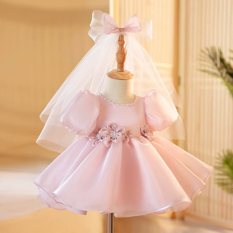 ✨ Descrizione del Vestito Rosa:

Un abito da principessa elegante e delicato in un rosa cipria incantevole, realizzato in organza, una tela trasparente e luminosa che conferisce un tocco di magia e raffinatezza al look. Questa stoffa è perfetta per creare volume grazie ai suoi plissettati verticali, che fanno sì che l'abito fluttui in modo etereo. La parte inferiore del vestito è arricchita da due fiocchi in organza a forma di rosa con perle, che aggiungono un dettaglio sofisticato e prezioso.

🌸 Caratteri