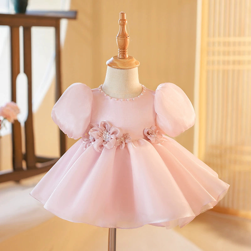 ✨ Descrizione del Vestito Rosa:

Un abito da principessa elegante e delicato in un rosa cipria incantevole, realizzato in organza, una tela trasparente e luminosa che conferisce un tocco di magia e raffinatezza al look. Questa stoffa è perfetta per creare volume grazie ai suoi plissettati verticali, che fanno sì che l'abito fluttui in modo etereo. La parte inferiore del vestito è arricchita da due fiocchi in organza a forma di rosa con perle, che aggiungono un dettaglio sofisticato e prezioso.

🌸 Caratteri