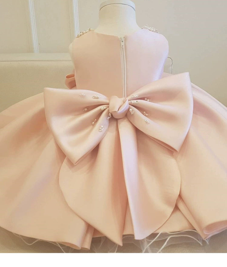 Un abito da cerimonia raffinato e senza tempo, realizzato in satin rosa cipria lucido, impreziosito da plissettature verticali che donano eleganza e movimento. Sotto la gonna, numerosi strati di tulle vaporoso creano volume, donando al vestito un effetto principesco.

🌸 Caratteristiche:

Materiale: Satin liscio e brillante con strati di tulle soffice.
Colore: Rosa cipria, delicato e raffinato.
Design: Plissettature verticali per un look sofisticato e armonioso.
Decorazioni:
Cintura in vita con perle che ag